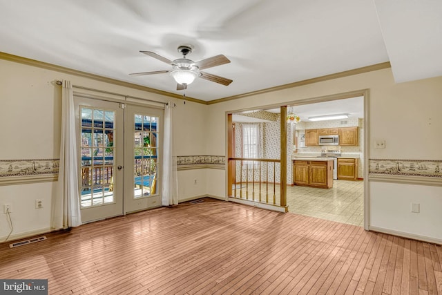 spare room featuring french doors, light hardwood / wood-style floors, ceiling fan, and crown molding