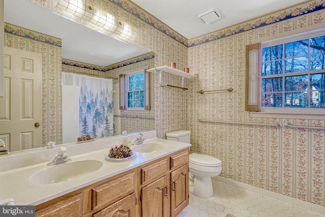 bathroom with tile patterned flooring, vanity, and toilet