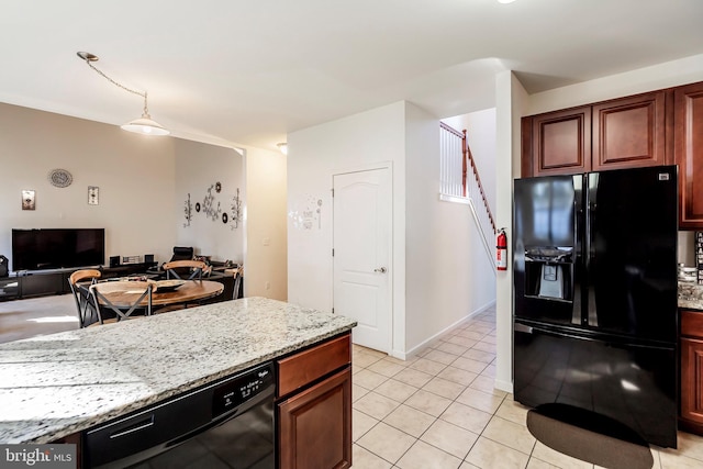 kitchen featuring black appliances, light stone counters, and light tile patterned floors