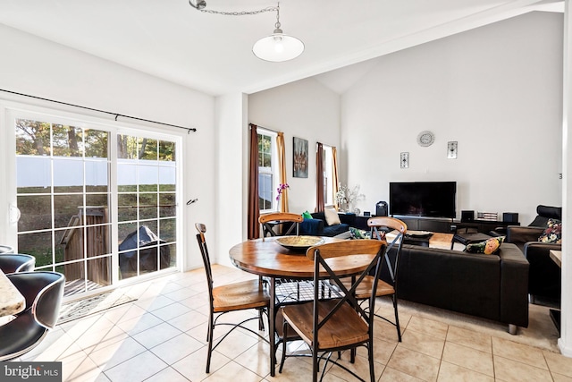 tiled dining space with lofted ceiling