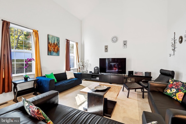 carpeted living room with high vaulted ceiling