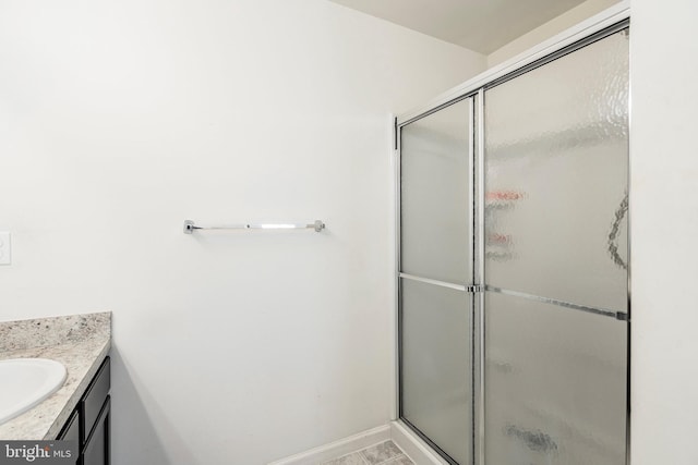 bathroom with tile patterned flooring, vanity, and a shower with door