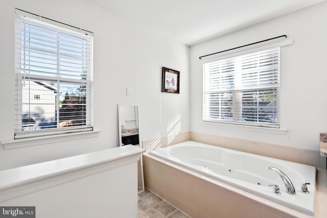 bathroom featuring tile patterned flooring and tiled tub