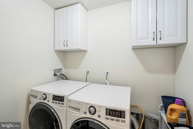 laundry area with cabinets and washing machine and clothes dryer