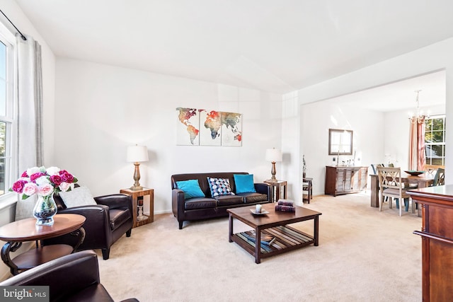 carpeted living room featuring a notable chandelier