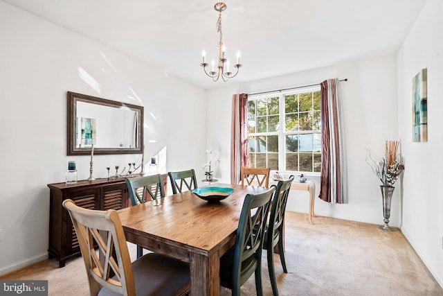 carpeted dining area featuring an inviting chandelier