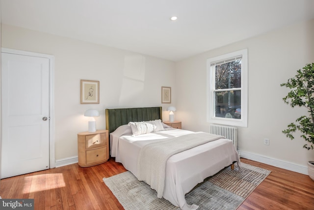 bedroom featuring radiator and light hardwood / wood-style flooring