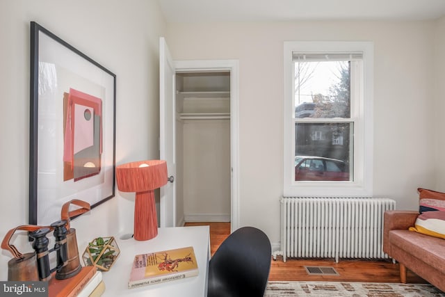 office space featuring radiator heating unit and hardwood / wood-style flooring