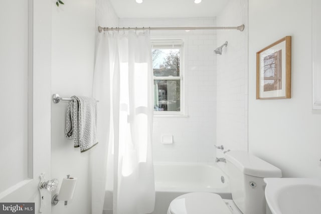 bathroom featuring shower / bathtub combination with curtain and toilet