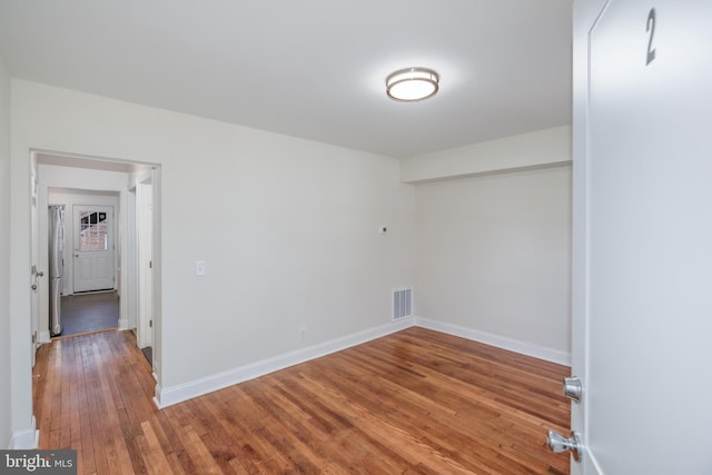 unfurnished room with wood-type flooring