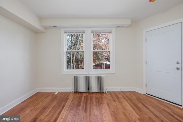 spare room with wood-type flooring and radiator