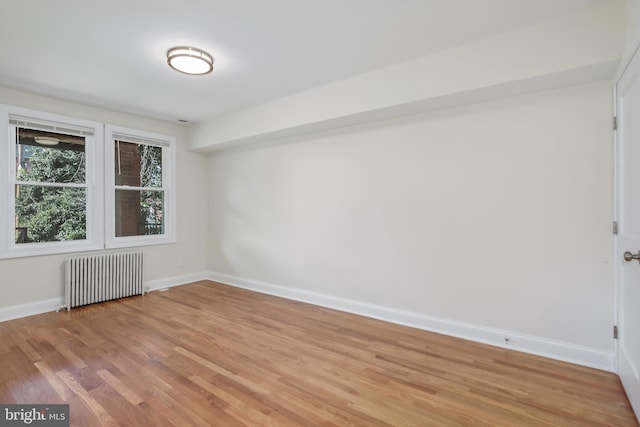 empty room with hardwood / wood-style flooring and radiator