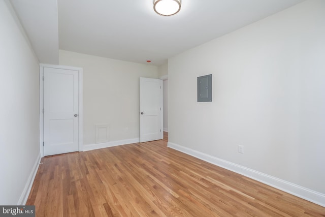 interior space featuring electric panel and light hardwood / wood-style floors