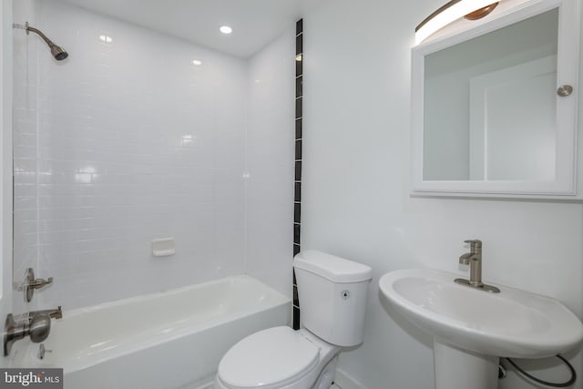 full bathroom with tiled shower / bath combo, toilet, and sink