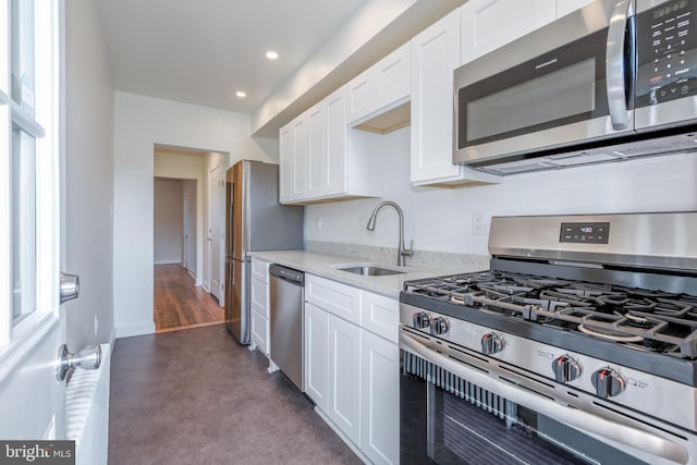 kitchen featuring white cabinets, stainless steel appliances, plenty of natural light, and sink