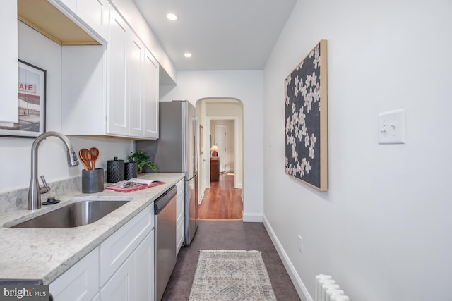 kitchen featuring sink, light stone countertops, dark hardwood / wood-style flooring, white cabinetry, and stainless steel appliances