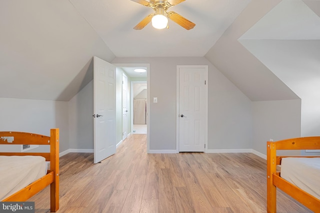 bedroom with ceiling fan, light hardwood / wood-style flooring, and lofted ceiling