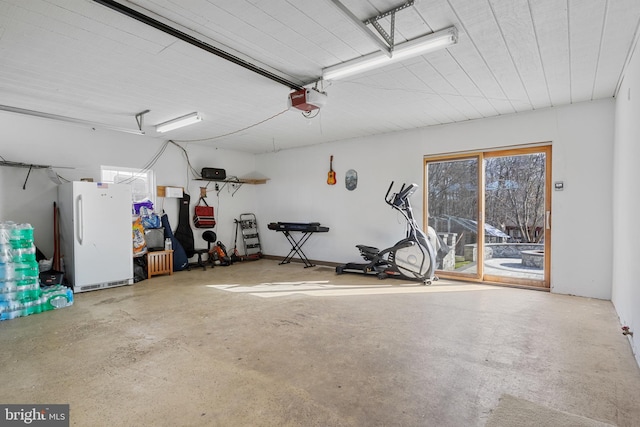 garage featuring white refrigerator and a garage door opener