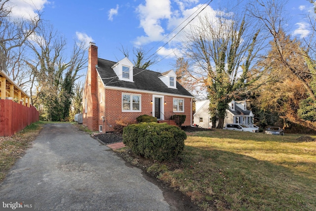 cape cod-style house with a front lawn