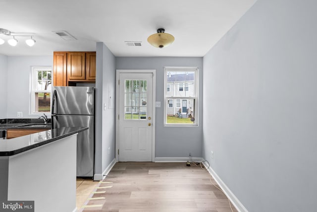 kitchen featuring sink, stainless steel refrigerator, and light hardwood / wood-style flooring