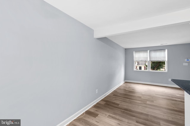 interior space with beam ceiling and hardwood / wood-style floors