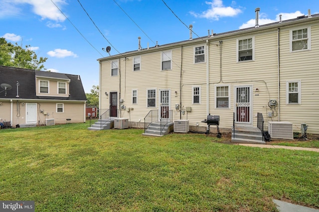 rear view of property with a yard and central AC unit