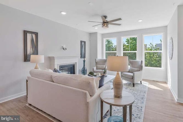 living room with light wood-type flooring and ceiling fan