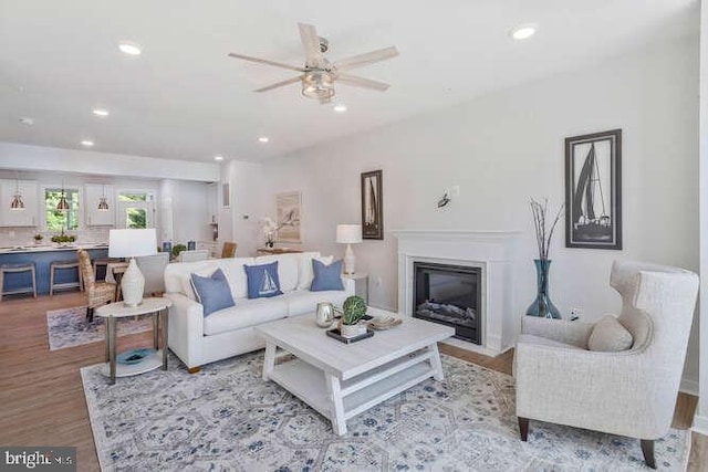 living room with light wood-type flooring and ceiling fan