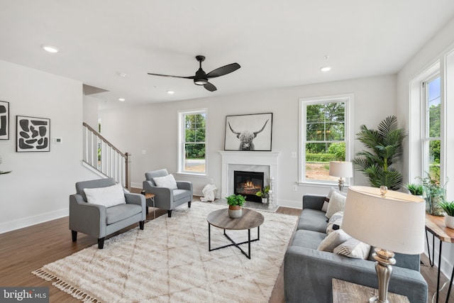 living room with light wood-type flooring, plenty of natural light, and ceiling fan