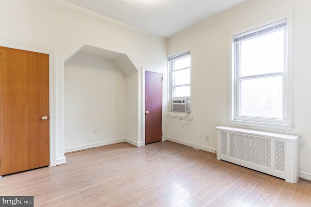 bonus room featuring radiator, cooling unit, and light hardwood / wood-style floors