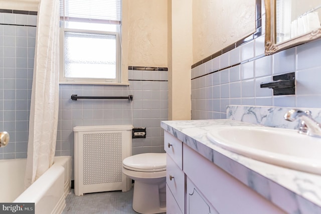 full bathroom with shower / tub combo, vanity, tile walls, radiator heating unit, and toilet