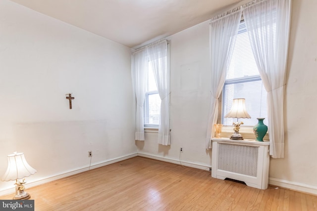 empty room with radiator and light hardwood / wood-style flooring