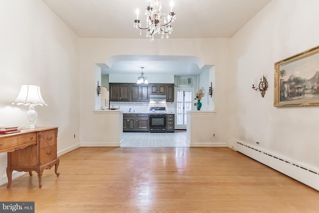 living room with an inviting chandelier, a baseboard radiator, and light hardwood / wood-style floors