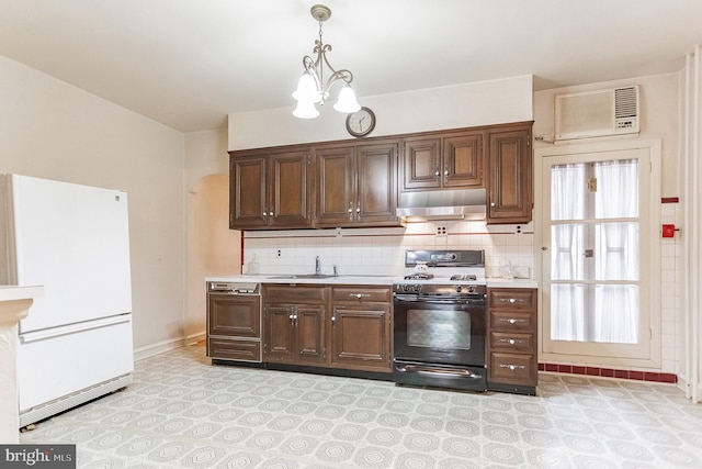 kitchen featuring black gas range oven, dark brown cabinets, sink, decorative light fixtures, and white fridge