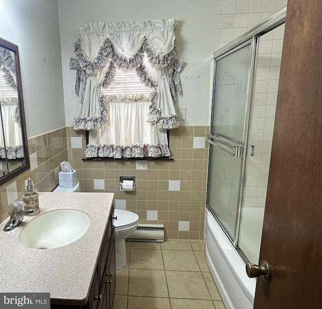 full bathroom with toilet, tile patterned floors, tile walls, and a baseboard heating unit