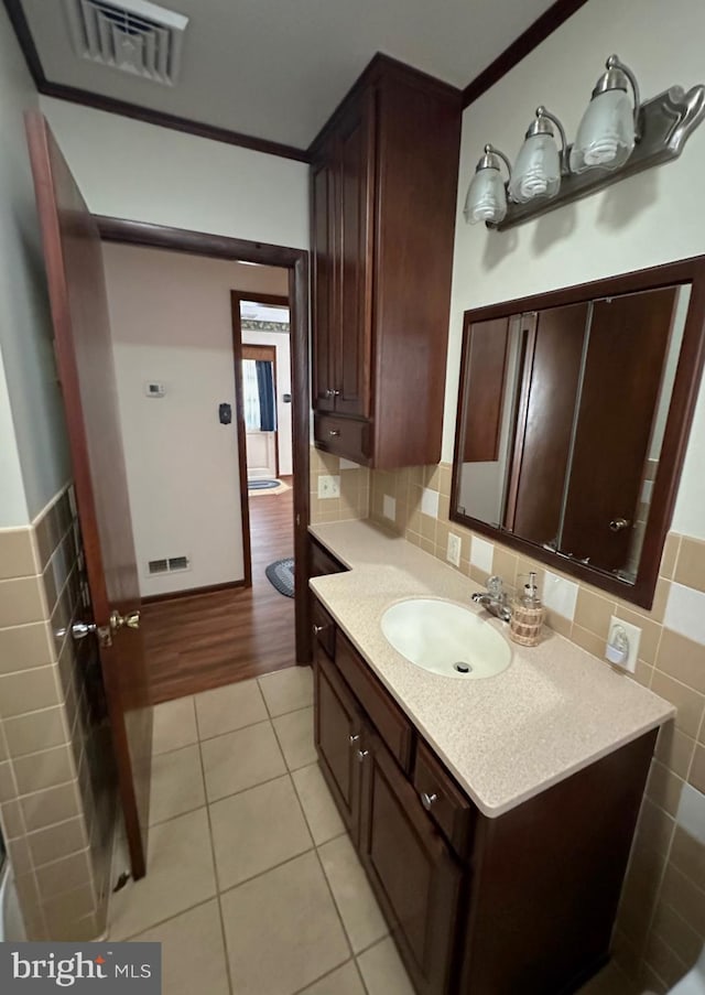 bathroom with vanity, wood-type flooring, crown molding, and tile walls