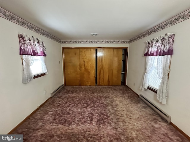 unfurnished bedroom featuring carpet, a closet, and a baseboard heating unit