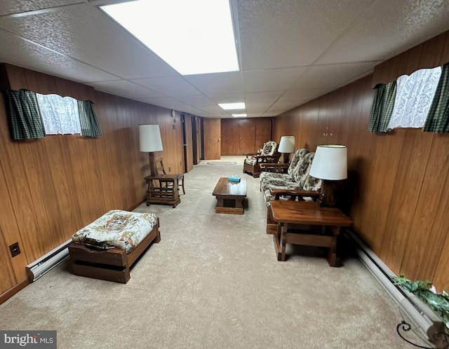 living area featuring light carpet, a drop ceiling, and baseboard heating