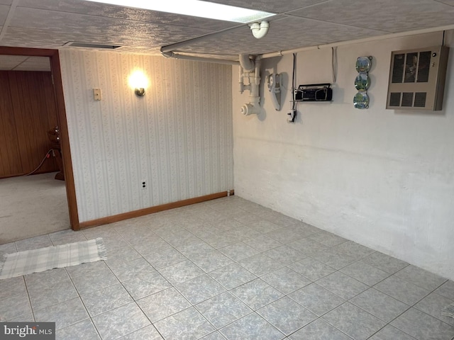 basement featuring wooden walls and light tile patterned flooring