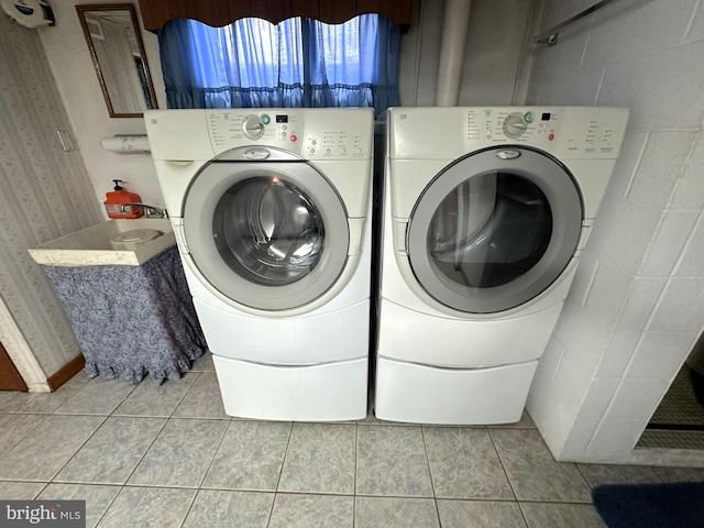 laundry area featuring separate washer and dryer and light tile patterned flooring