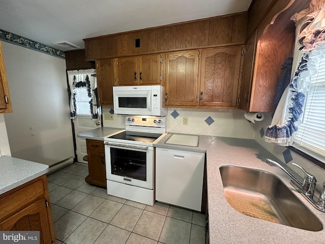 kitchen featuring decorative backsplash, white appliances, plenty of natural light, and sink