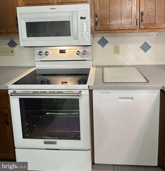 kitchen featuring decorative backsplash and white appliances