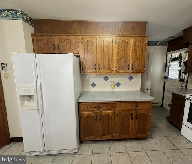 kitchen featuring decorative backsplash, white appliances, and light tile patterned floors