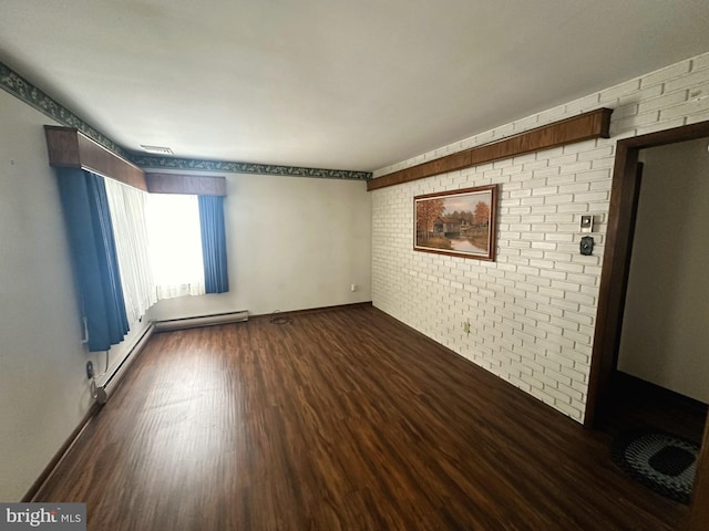 unfurnished room with baseboard heating, brick wall, and dark hardwood / wood-style floors