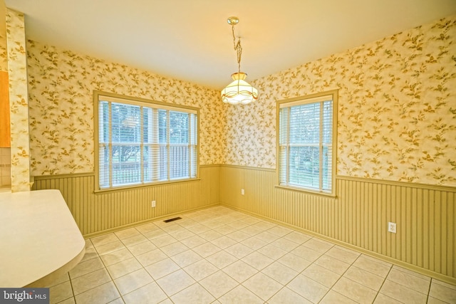 tiled empty room featuring a healthy amount of sunlight