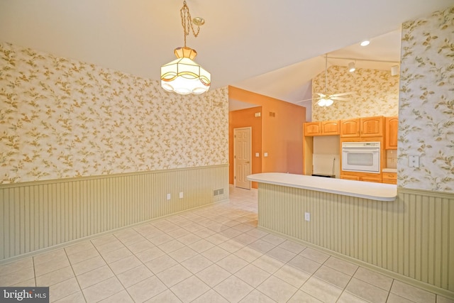 kitchen featuring ceiling fan, hanging light fixtures, oven, lofted ceiling, and light tile patterned flooring