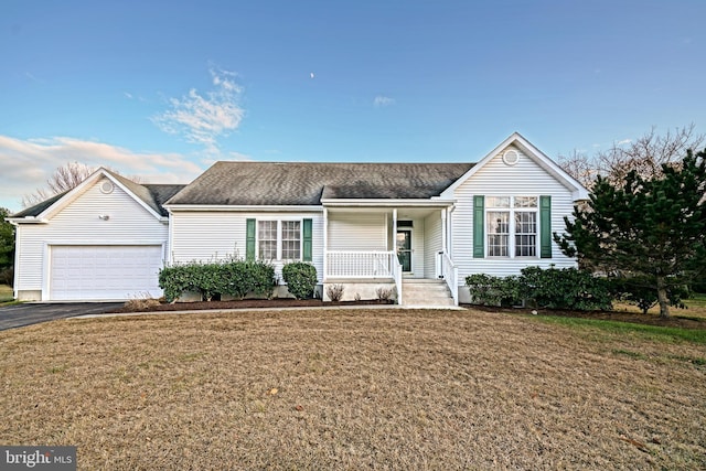 ranch-style house featuring covered porch, a garage, and a front lawn