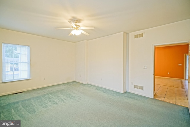 carpeted spare room with ceiling fan