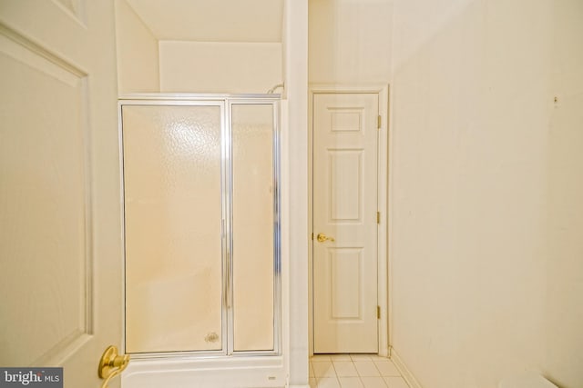 bathroom featuring tile patterned floors and a shower with shower door