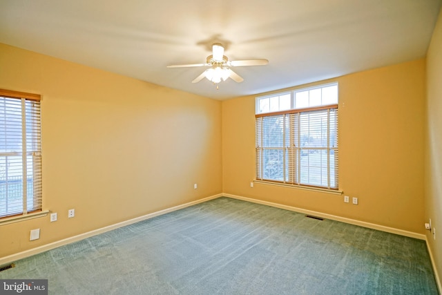 carpeted spare room featuring ceiling fan